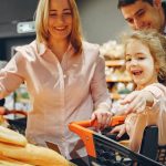 Happy family with a child shopping in a supermarket, smiling and bonding.